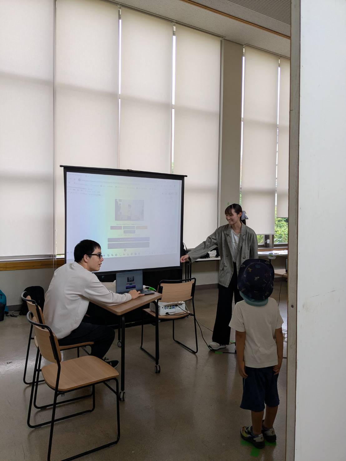 小学生にやさしく解説する学生スタッフ